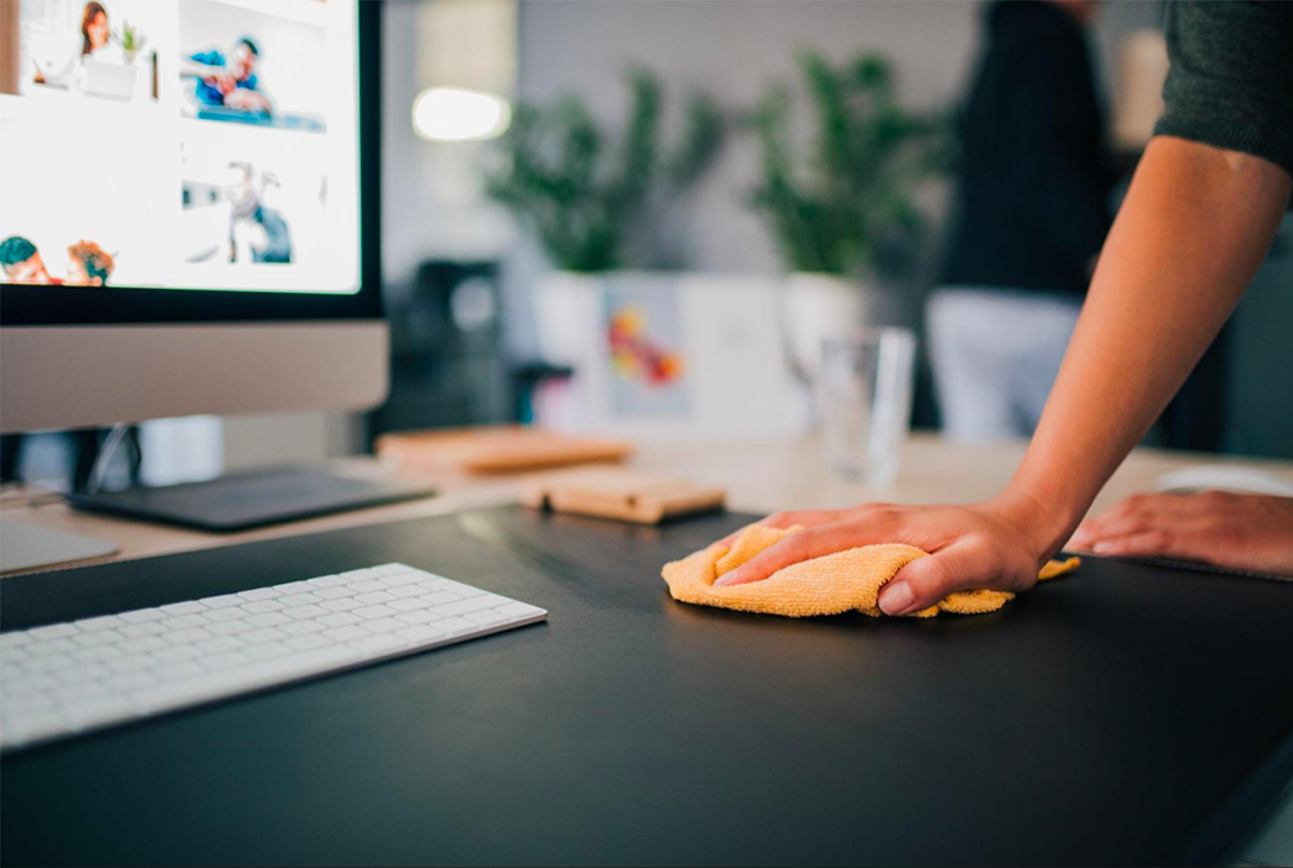 A cleaner using a cloth on office desk