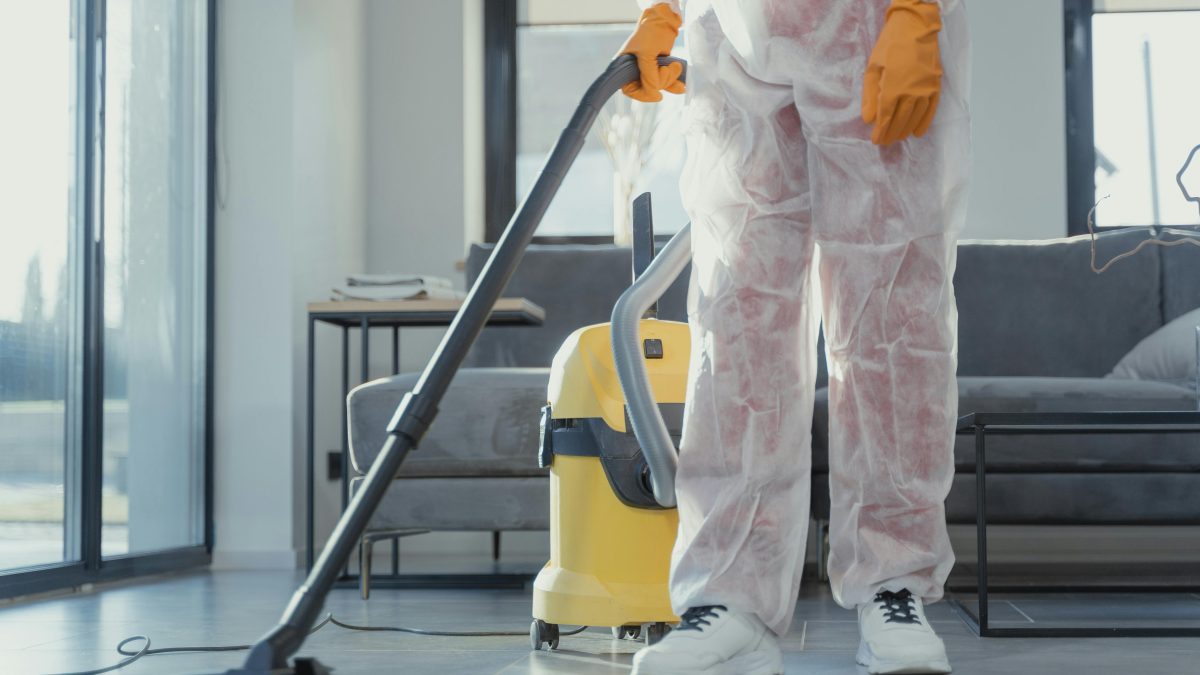 Person in protective clothing cleaning a floor