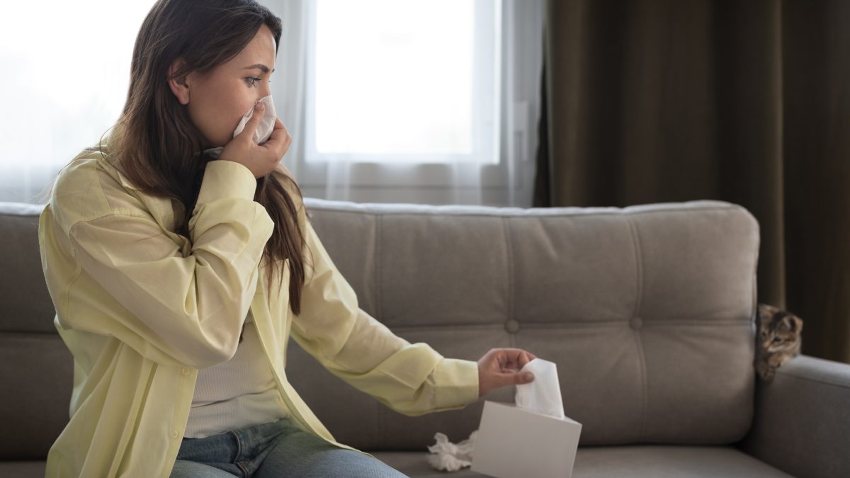 A lady blowing her nose with tissue paper