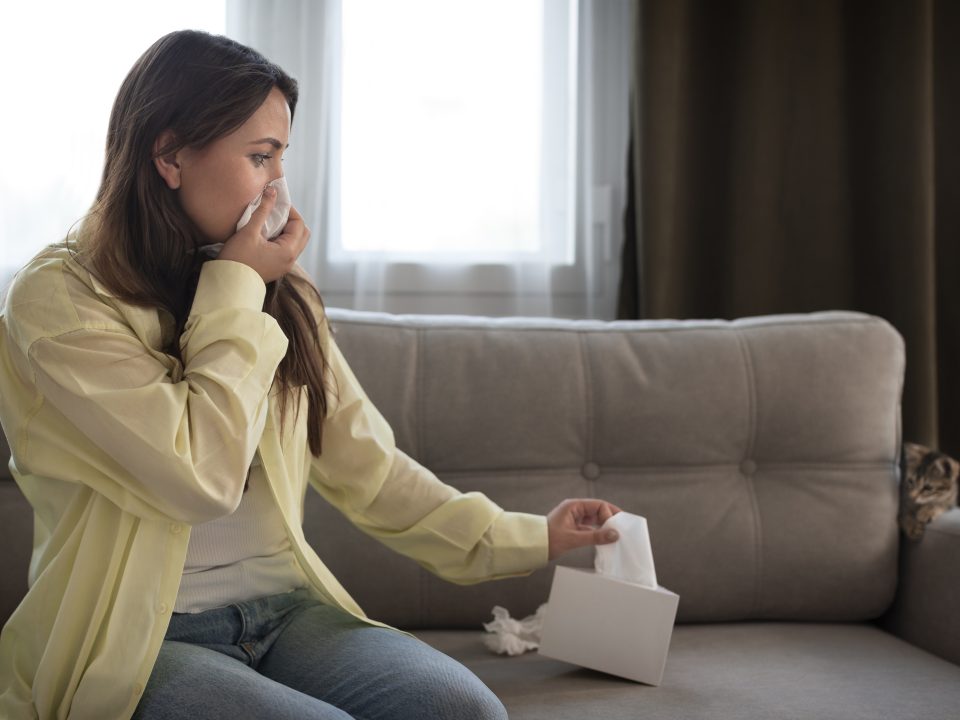 A lady blowing her nose with tissue paper